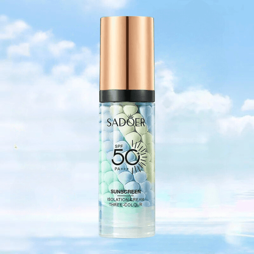 A bottle of SADOER sunscreen with SPF 50 and PA+++, featuring a gold cap and filled with green, blue, and white beads, set against a cloudy sky background.