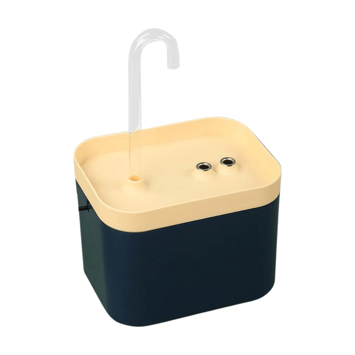 A compact, rectangular pet water fountain with a dark blue base and a light beige top. It features a clear curved spout on the top surface, along with two small circular sensors or buttons.