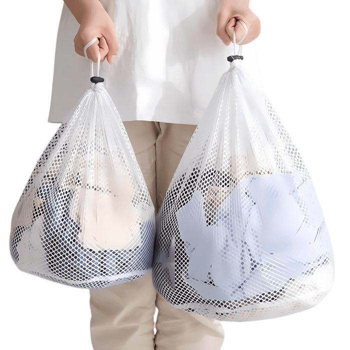 A person holding two large mesh laundry bags filled with clothes, demonstrating the bags' capacity and durability for handling bulky laundry loads. Display on white background.