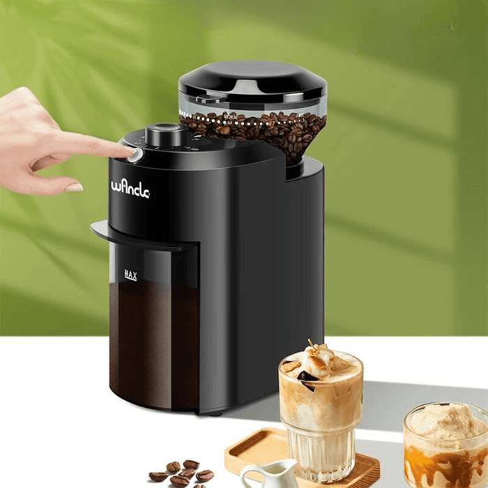 A hand is pressing the on/off button on the grinder. It's set on a counter with two iced coffee drinks, emphasizing its ease of use and versatility.