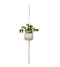 A single macrame plant holder with two tiers, each holding a white pot with green plants. The top pot has a design with brown dripping glaze.