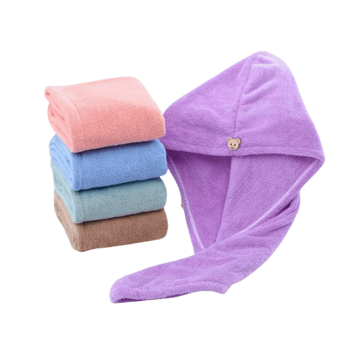 A stack of hooded towels in various colors (pink, blue, green, beige, and purple) displayed with one towel opened to show its hood and tail-like end. The towels look soft and fluffy, and each has a bear-shaped wooden button for fastening.