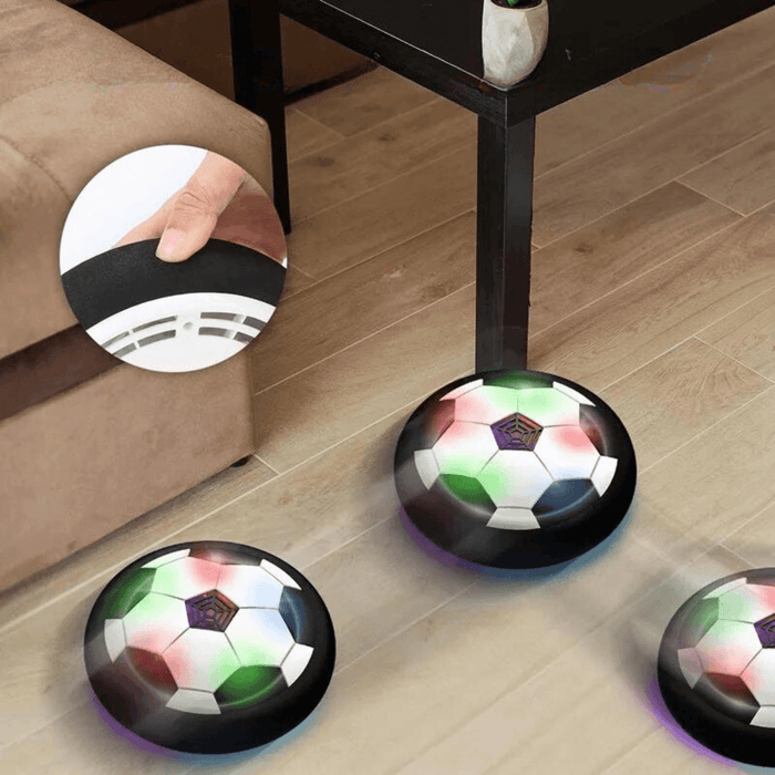 Three hover soccer balls moving around a living room, showing a close-up of its foam bumper.