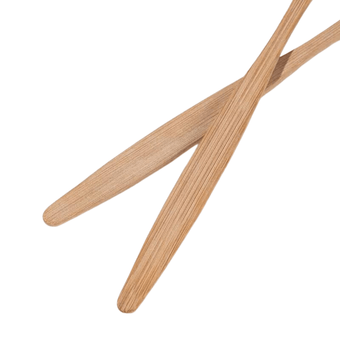 A close-up view of two bamboo toothbrushes, showing the smooth texture and natural grain of the bamboo material.