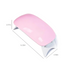 A compact pink nail dryer with dimensions marked: 5.12 inches in length, 2.36 inches in width, and 1.57 inches in height. The dryer has a sleek, curved design and rests on small, foldable legs.