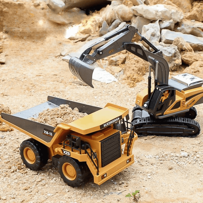 Toy excavator loading sand into a dump truck in a desert-like setting. Both vehicles have operational lights and are colored yellow and grey.