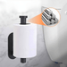 A practical demonstration of the toilet paper holder mounted on a bathroom wall, holding a standard roll of toilet paper. The image focuses on the mounting mechanism, showcasing the robust and discreet attachment that ensures stability and ease of use.