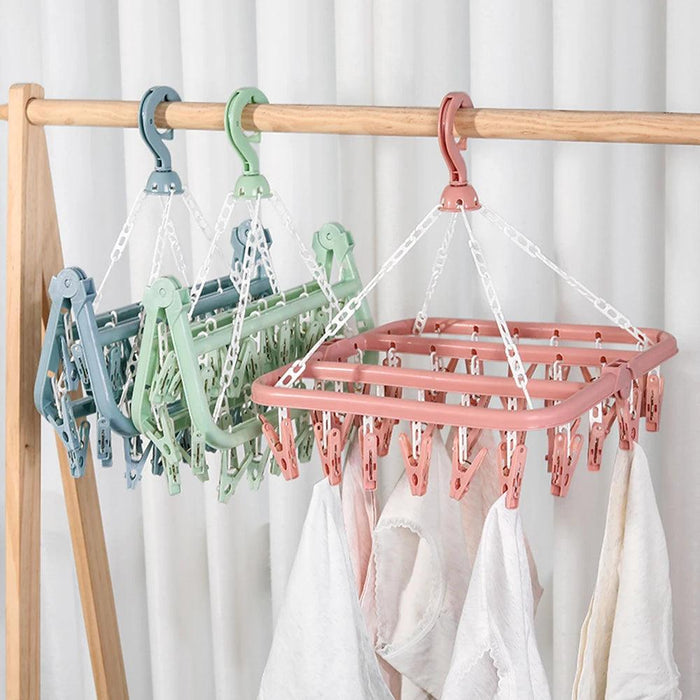 3 Folding Clothes Dryer Racks, hanging on wood stand with white curtain in the background.