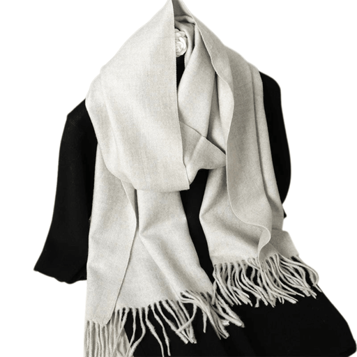 A light gray scarf is draped over a black outfit, showcasing its soft fabric and fringed ends. The scarf adds a touch of warmth and elegance to the ensemble.