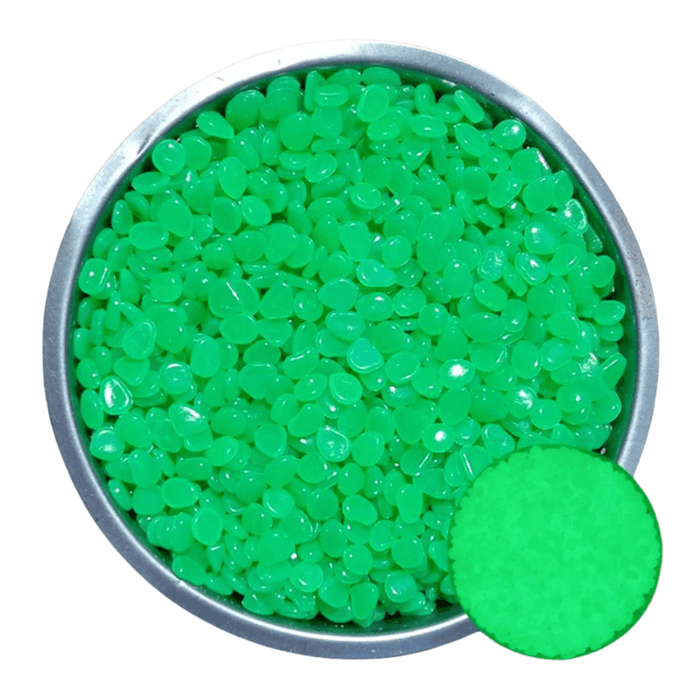 A metal bowl filled with green pebbles. A small inset shows the pebbles glowing green in the dark.