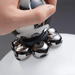  A close-up of a hand holding the trimmer, emphasizing the grip and the design of the rotating blades on the head. The trimmer is in use, demonstrating its ergonomic design.