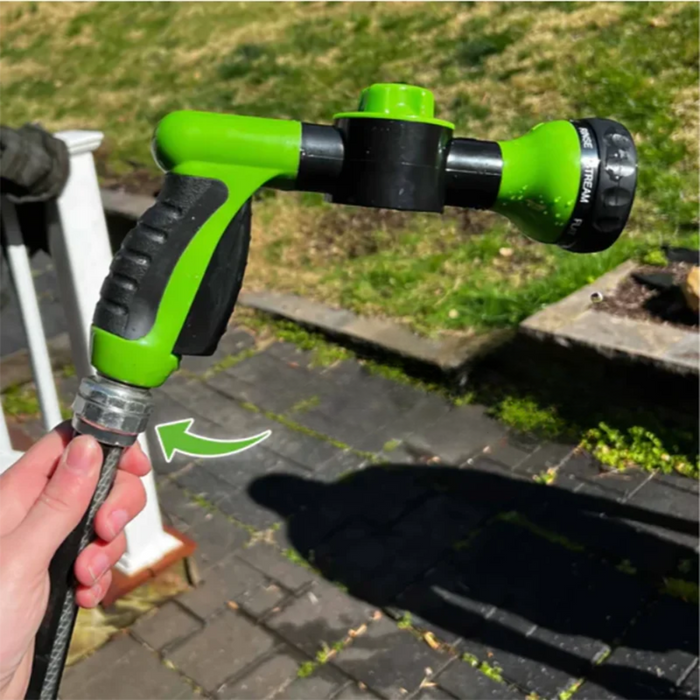 A close-up of a green and black hose nozzle being connected to a garden hose, with an arrow indicating the connection point.