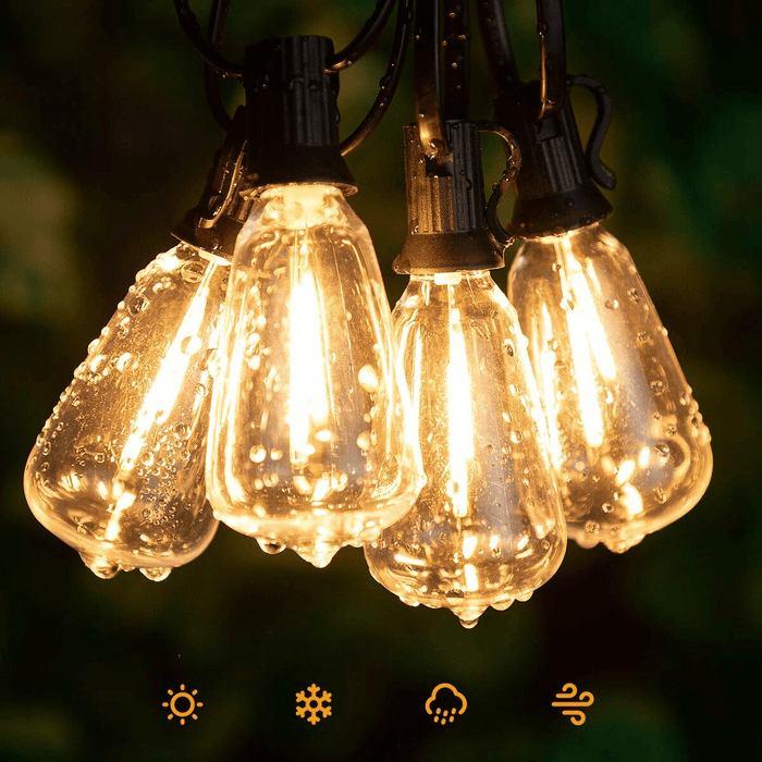 A close-up of several vintage-style Edison light bulbs hanging together, lit warmly and covered with droplets of water, indicating they are waterproof. Icons below suggest their suitability for different weather conditions (sunny, snowy, rainy, windy).