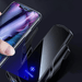 A close-up of a wireless phone charger with a phone being placed on it, showing the charging indicator light.