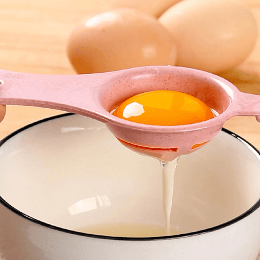 Pink egg separator being used to separate an egg yolk.