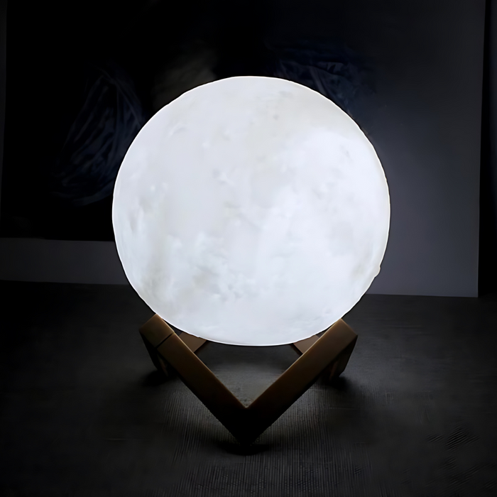 A white moon lamp glowing brightly on a wooden stand. The dark background contrasts with the bright white light of the lamp.