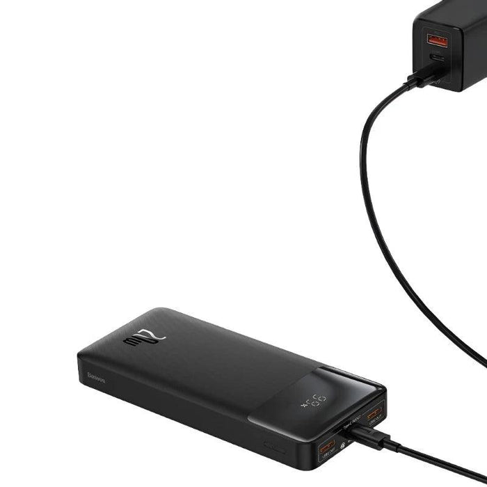 A black power bank connected to a charger. The image shows the device's charging ports and digital display, highlighting its functionality and ease of use.