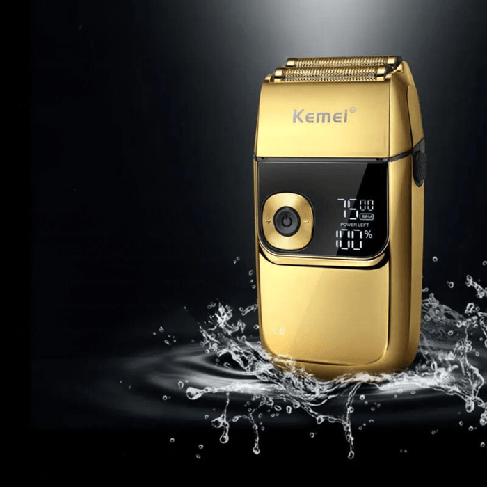 A gold Kemei shaver in action, surrounded by splashes of water, showcasing its waterproof capability.