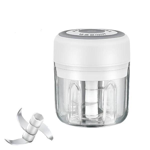 A close-up of a food chopper with a white lid, showcasing the blade and clear container.