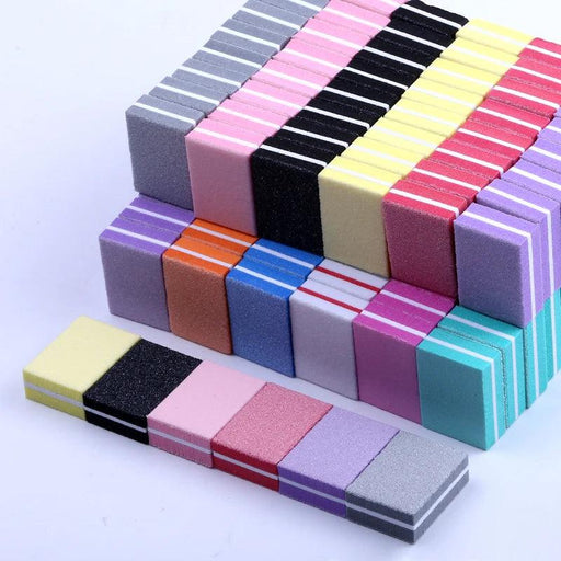 Colorful nail buffers stacked in rows, featuring combinations of pink, grey, black, yellow, orange, blue, and more.