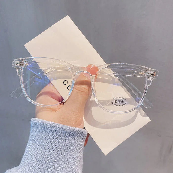 Clear-framed glasses held in front of a white envelope