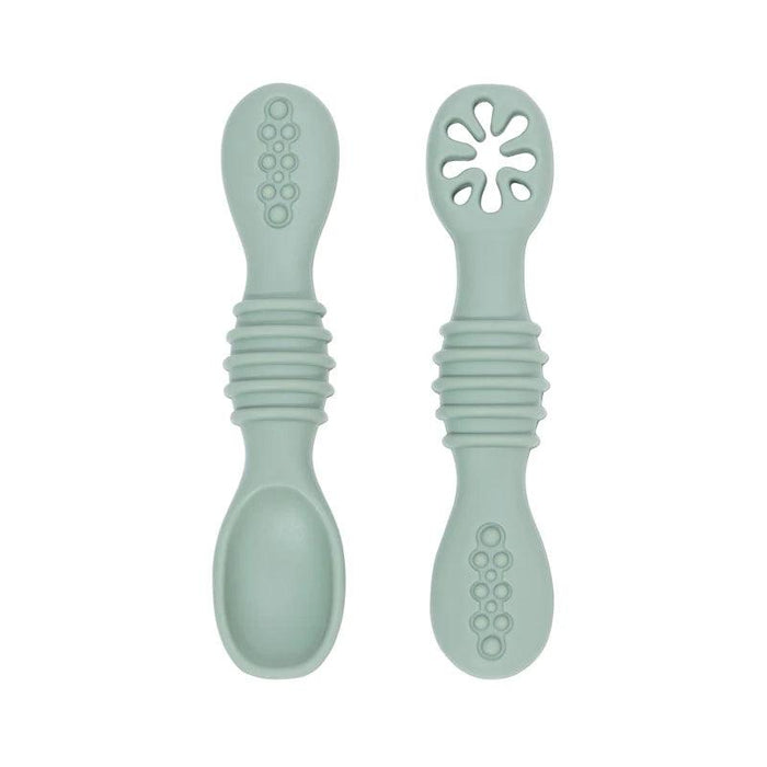 A close-up of two gray baby spoons, one with a regular spoon shape and the other with a cut-out flower design, against a white background.