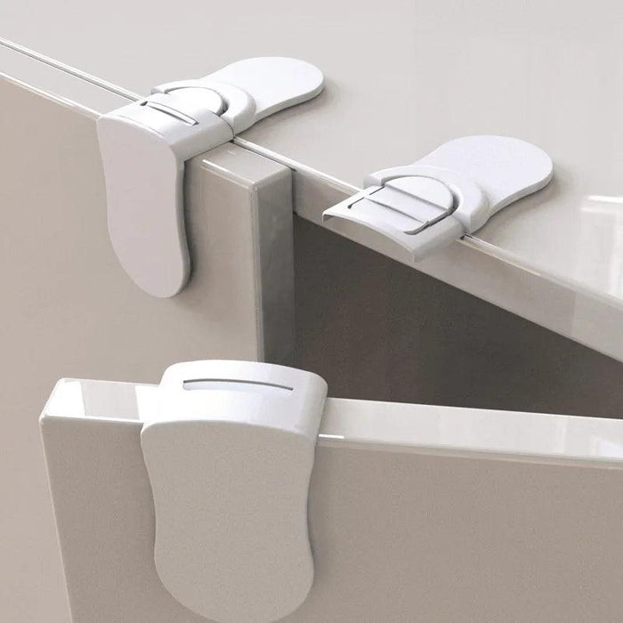 Three white safety locks securely fastened to the corners of a glossy cabinet, keeping the doors slightly ajar, demonstrating the locks' placement and function on different cabinet sections.