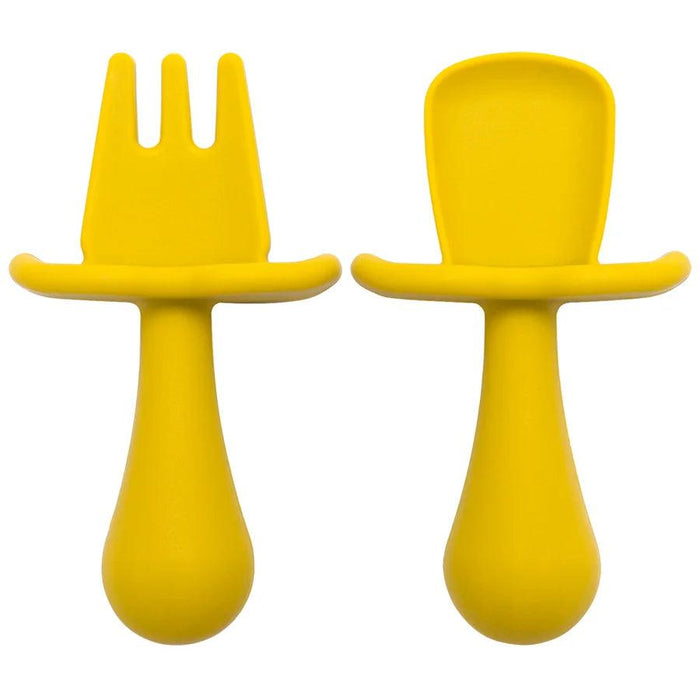 A close-up shot of two yellow silicone baby utensils, a fork and a spoon, showing their detailed design and texture.