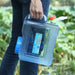 a person carrying the water container by its handle, demonstrating its portability and ease of use.