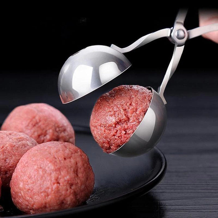 Stainless steel meatball tongs placing a meatball on a plate with other meatballs.