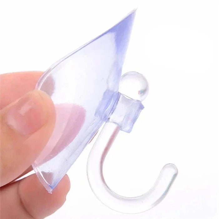 Close-up of a transparent suction cup hook being held between fingers.