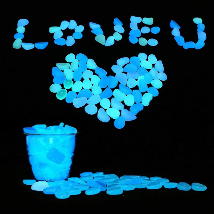 Blue glowing pebbles arranged to form the words "LOVE U" and a heart shape, with a glass filled with blue glowing pebbles at the bottom.