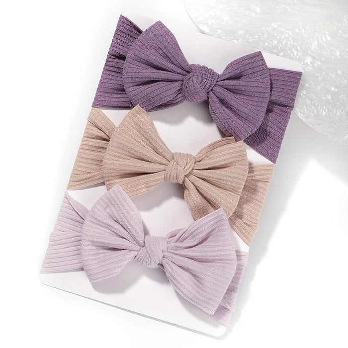 A set of 3 Baby Bow Headbands with different colors.