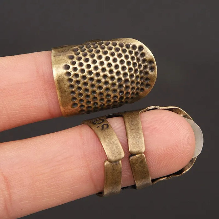 Vintage sewing thimble shown on fingers with his front and back sides.