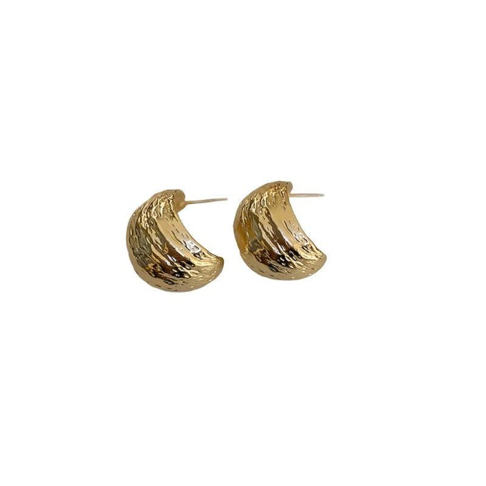 a pair of gold hoop earrings with a hammered, textured finish. The texture gives the earrings a rustic and handcrafted appearance.