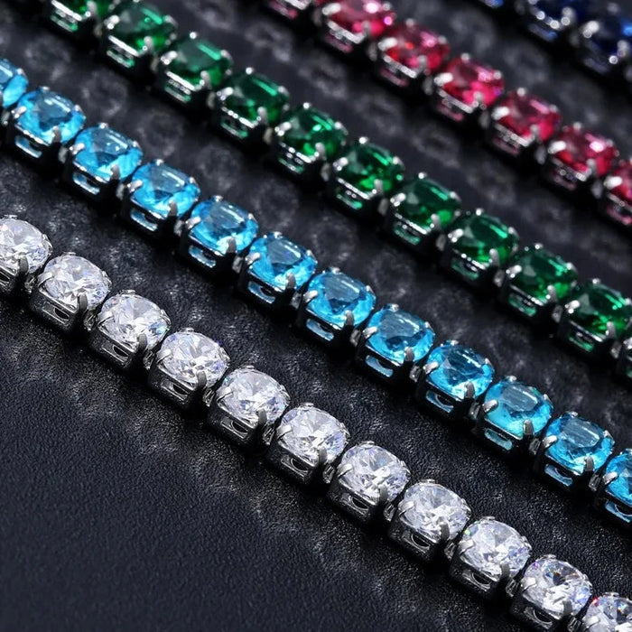 Close-up of various colorful stone bracelets lined up on a dark surface.