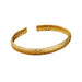 Gold cuff bracelet with a pebble-like textured finish, displayed on a white background.