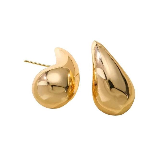 a pair of gold teardrop earrings placed against a white background. The earrings have a smooth, polished finish and are designed to be elegant and eye-catching. This image showcases the earrings' design and craftsmanship.