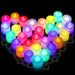 A collection of colorful LED tea light candles arranged in a heart shape. These candles come in various colors, including red, yellow, green, blue, and purple, each emitting a bright and vibrant light, creating a festive atmosphere.