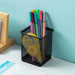 Black mesh pen holder on a desk, filled with colorful pens and a yellow correction tape.