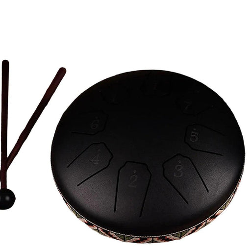  Black steel tongue drum display on white background with mallets nearby.