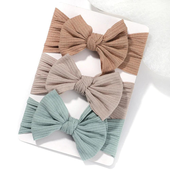 A set of 3 Baby Bow Headbands with different colors.