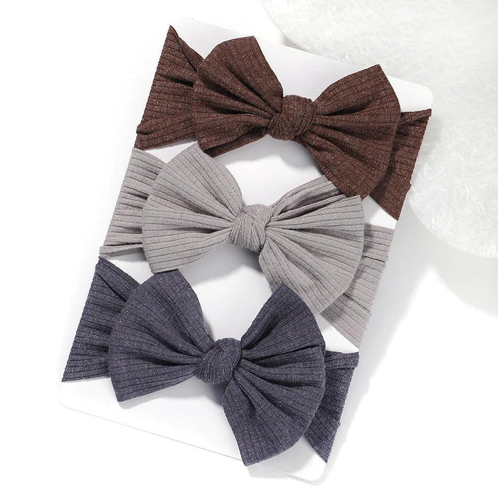 A set of 3 Baby Bow Headbands with different colors.