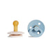 A beige pacifier with a yellow nipple and a blue, round pacifier with a ring handle.