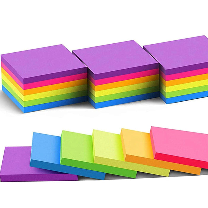 Several blocks of note pads in different colors are stacked tightly, some positioned to display their sides, emphasizing the various colors on a white background.