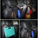  Multiple uses of headrest hooks in a car, holding bags, a blue case, and other items.