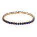 Gold tennis bracelet with blue stones on a white background.