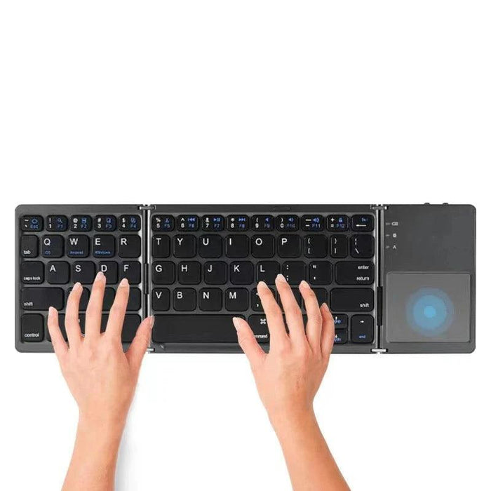 Hands typing on a portable folding keyboard with a touchpad.