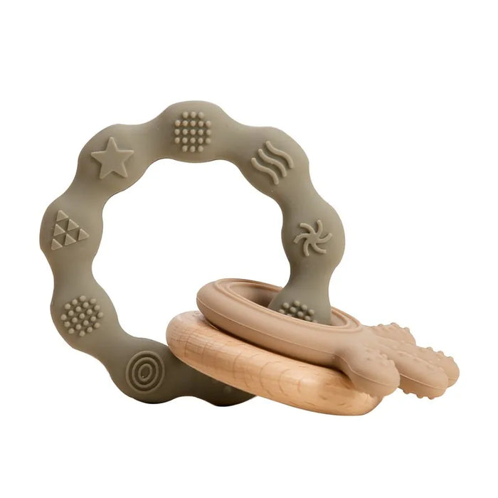 A gray silicone teether ring with beige various textured patterns and a wooden ring attached to it.