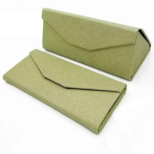 two green eyeglasses cases with a textured fabric exterior. One case is closed and lying flat, while the other is standing upright and open, showing the geometric design and envelope-style flap closure.